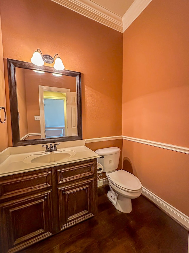 bathroom with ornamental molding, vanity, and toilet