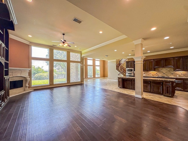 unfurnished living room with hardwood / wood-style flooring, decorative columns, ceiling fan, and a high end fireplace