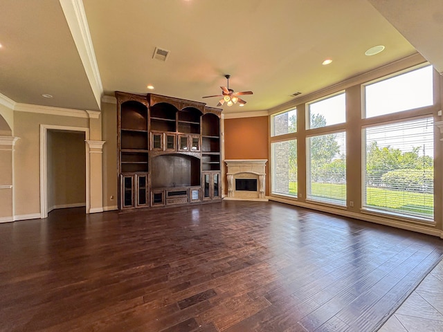 unfurnished living room with a premium fireplace, dark hardwood / wood-style flooring, ceiling fan, and crown molding