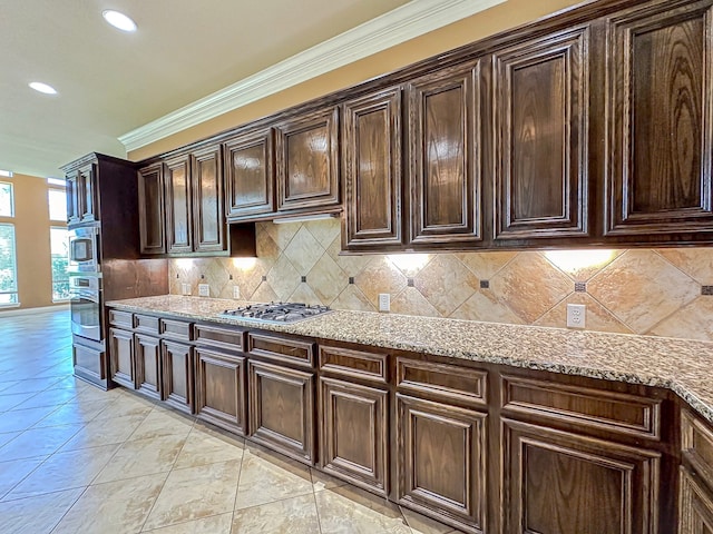 kitchen featuring appliances with stainless steel finishes, crown molding, light stone countertops, and backsplash