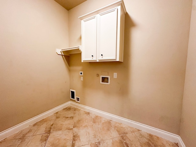 clothes washing area featuring cabinets, gas dryer hookup, washer hookup, light tile floors, and hookup for an electric dryer