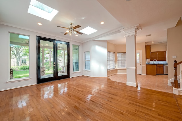 unfurnished living room featuring light hardwood / wood-style floors, ornate columns, ceiling fan, ornamental molding, and sink