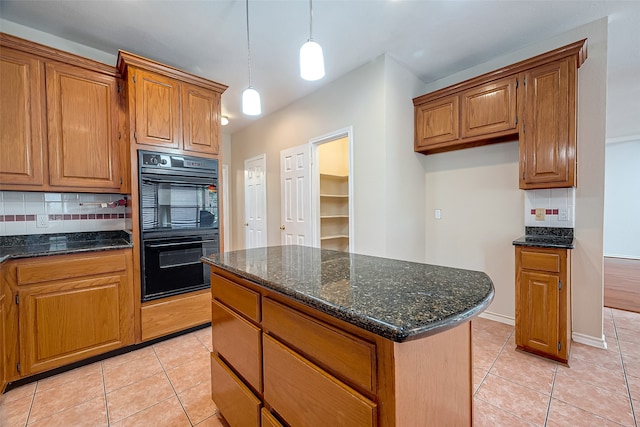 kitchen featuring light tile patterned floors, black double oven, and tasteful backsplash