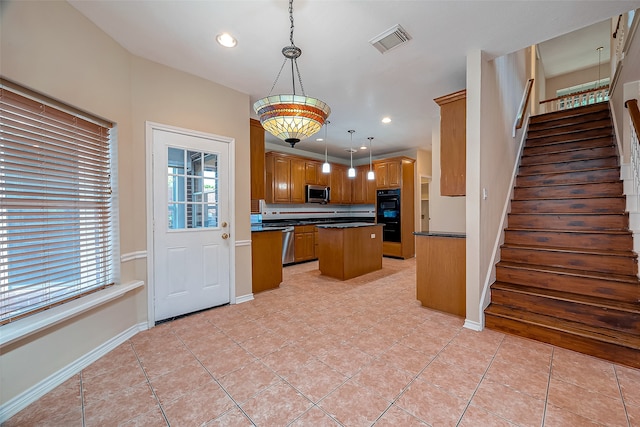 kitchen featuring a kitchen island, light tile patterned flooring, decorative light fixtures, and double oven