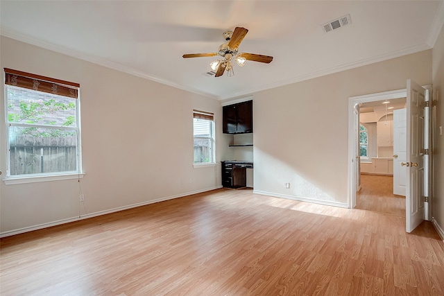 empty room featuring ceiling fan, light wood-type flooring, and crown molding