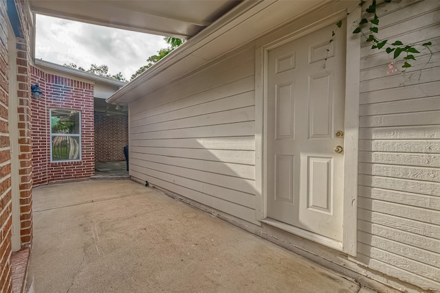 view of exterior entry featuring a patio area