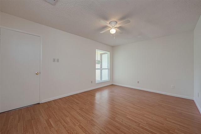 spare room with ceiling fan, light wood-type flooring, and a textured ceiling