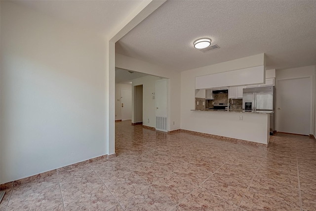 unfurnished living room with a textured ceiling