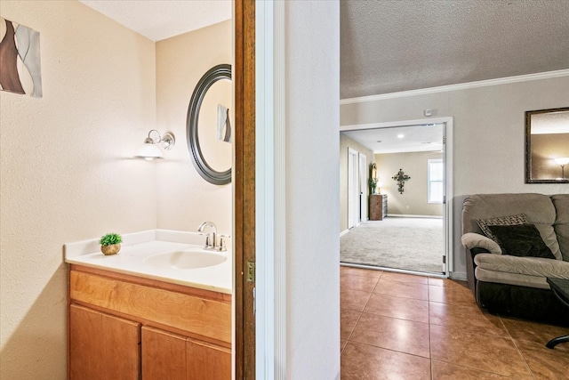 bathroom with vanity with extensive cabinet space, tile flooring, a textured ceiling, and crown molding