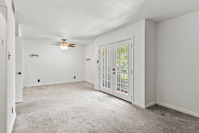 carpeted spare room with french doors, ceiling fan, and a textured ceiling