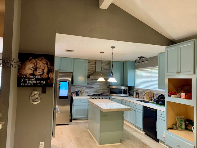 kitchen with a center island, wall chimney range hood, stainless steel appliances, sink, and vaulted ceiling