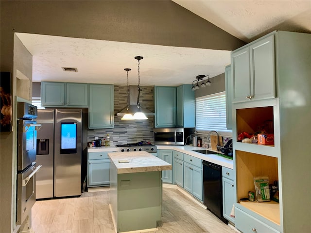 kitchen featuring stainless steel appliances, tasteful backsplash, a center island, wall chimney exhaust hood, and sink