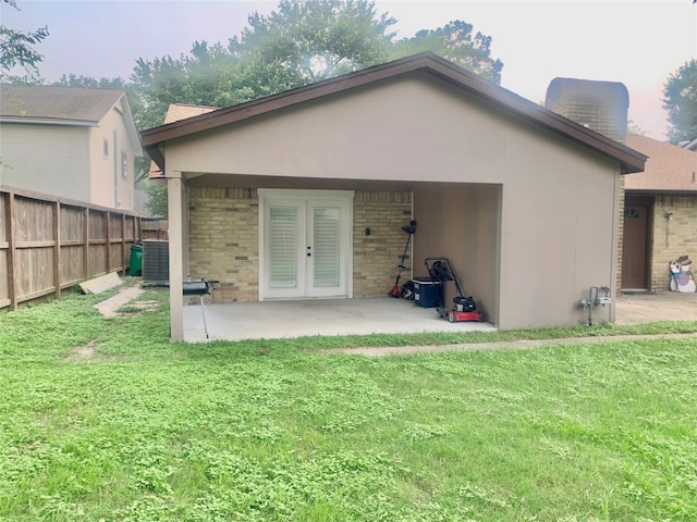 rear view of house featuring french doors, a lawn, and a patio area