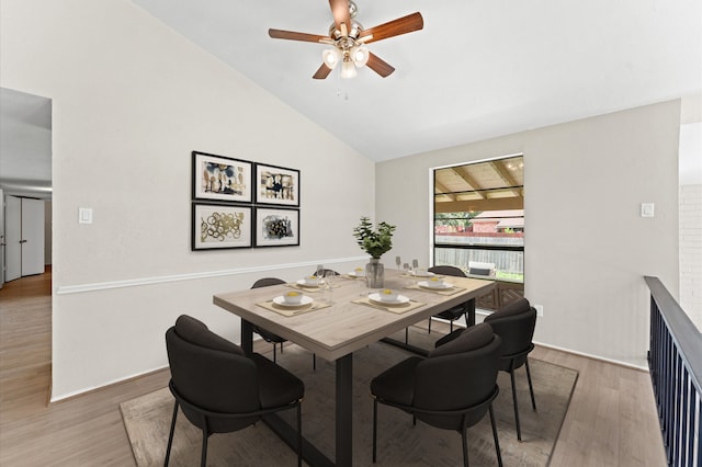 dining area featuring ceiling fan, hardwood / wood-style floors, and lofted ceiling