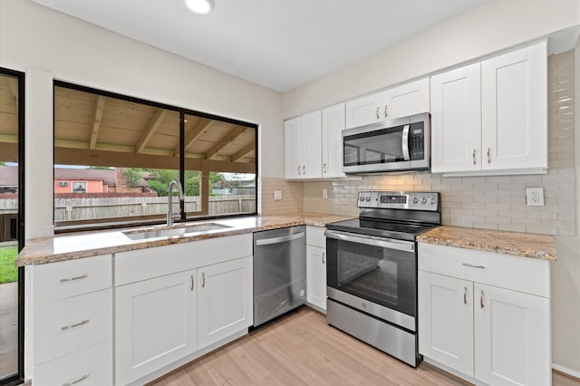 kitchen with light wood-type flooring, wood ceiling, sink, white cabinetry, and appliances with stainless steel finishes