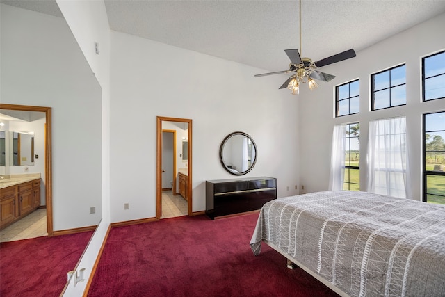 bedroom with high vaulted ceiling, carpet flooring, ceiling fan, and ensuite bath