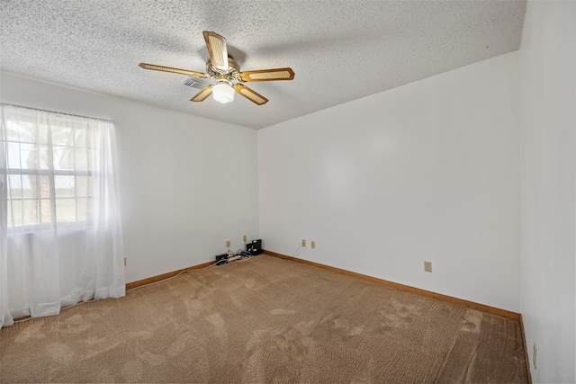 carpeted empty room with ceiling fan and a textured ceiling