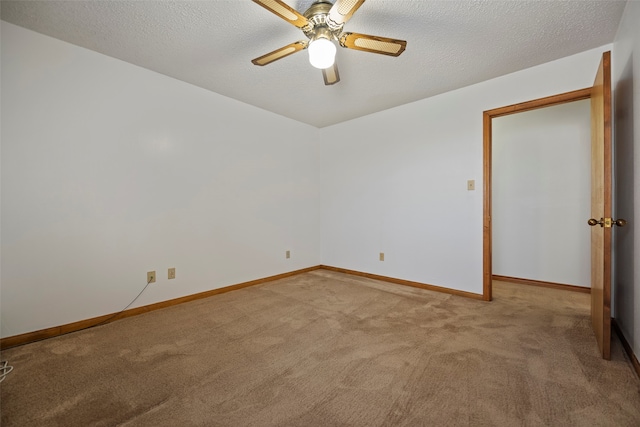 carpeted spare room with a textured ceiling and ceiling fan