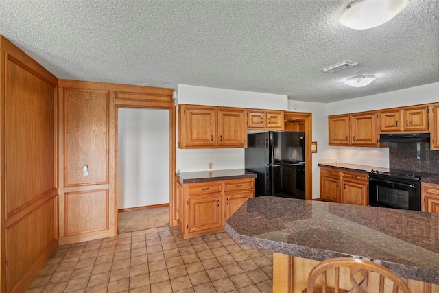 kitchen featuring exhaust hood, tasteful backsplash, light tile floors, black appliances, and a textured ceiling