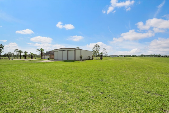 view of yard featuring an outdoor structure and a rural view