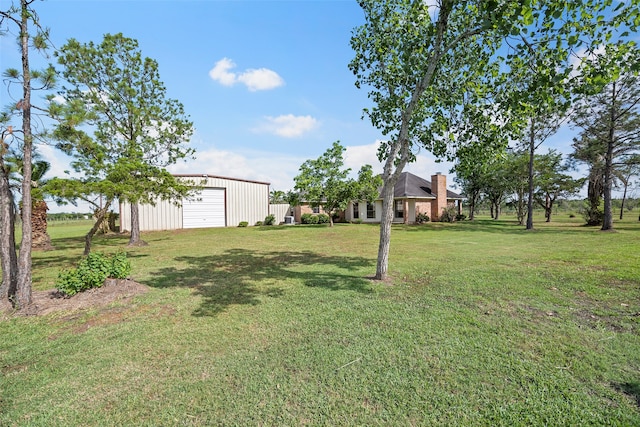 view of yard featuring a garage and an outdoor structure