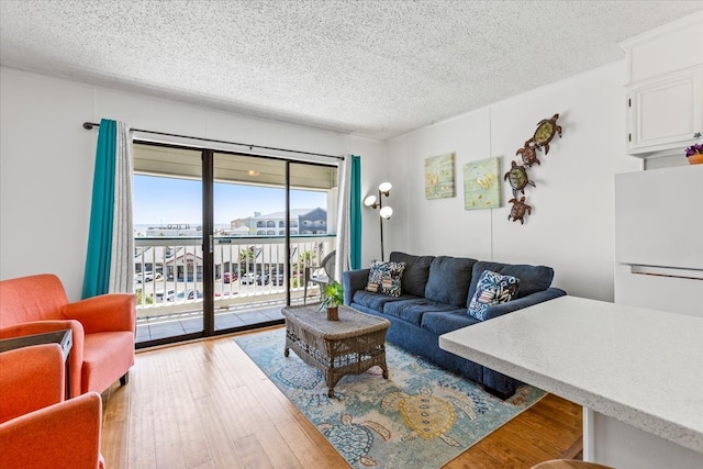 living room with a healthy amount of sunlight, hardwood / wood-style flooring, and a textured ceiling