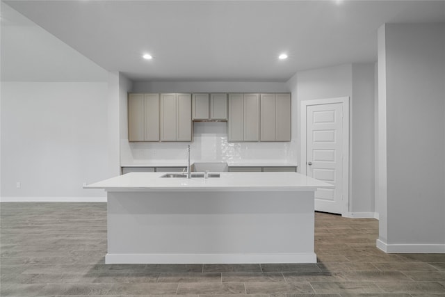 kitchen featuring a center island with sink, sink, and hardwood / wood-style flooring