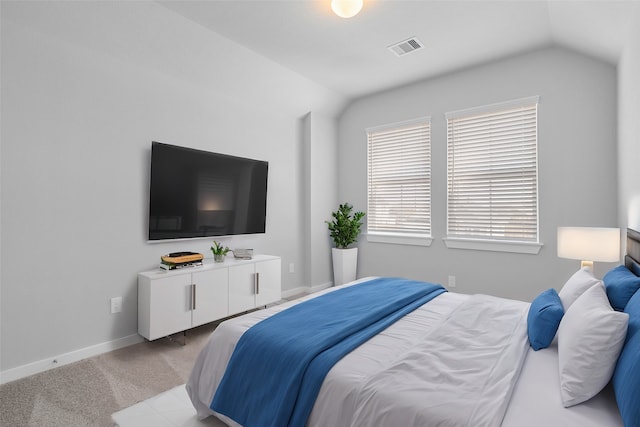 bedroom featuring lofted ceiling and light carpet