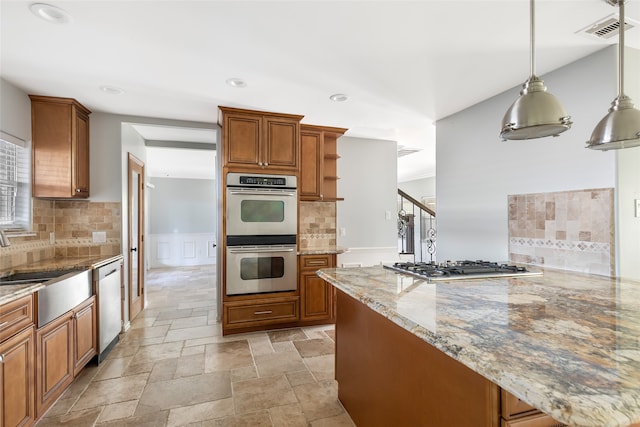 kitchen featuring backsplash, pendant lighting, light stone counters, and stainless steel appliances