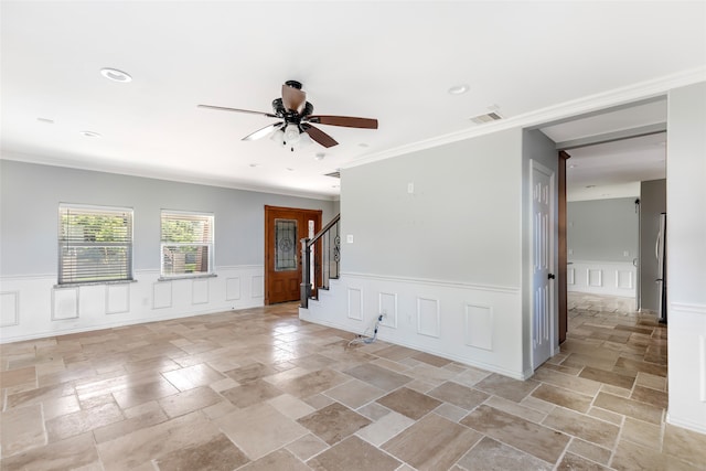 tiled empty room with ceiling fan and ornamental molding