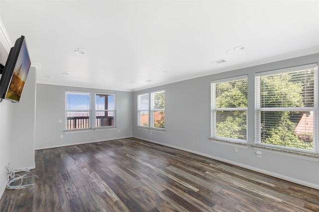 spare room with a wealth of natural light, ornamental molding, and dark hardwood / wood-style flooring