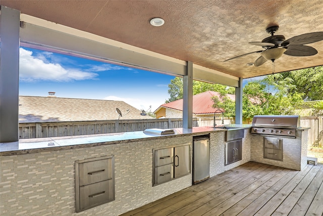 view of patio / terrace with exterior kitchen, ceiling fan, a wooden deck, area for grilling, and sink