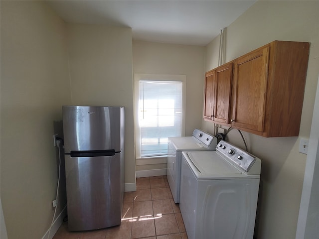 laundry area featuring independent washer and dryer, light tile flooring, cabinets, and hookup for a washing machine