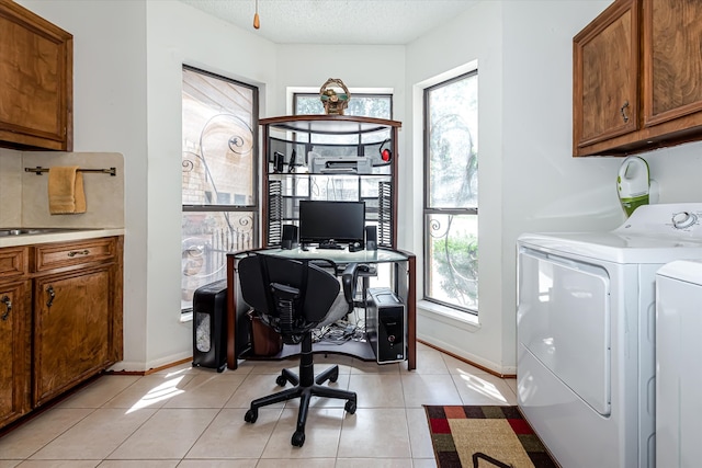 interior space with a wealth of natural light, independent washer and dryer, light tile flooring, and a textured ceiling