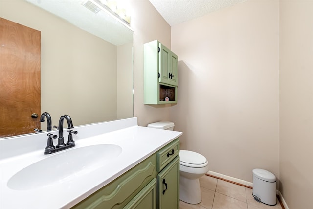 bathroom featuring tile floors, a textured ceiling, toilet, and vanity