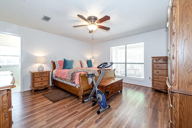 bedroom with a textured ceiling, ceiling fan, and hardwood / wood-style floors