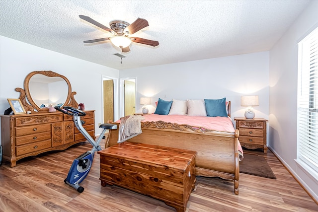 bedroom featuring hardwood / wood-style flooring, ceiling fan, and a textured ceiling