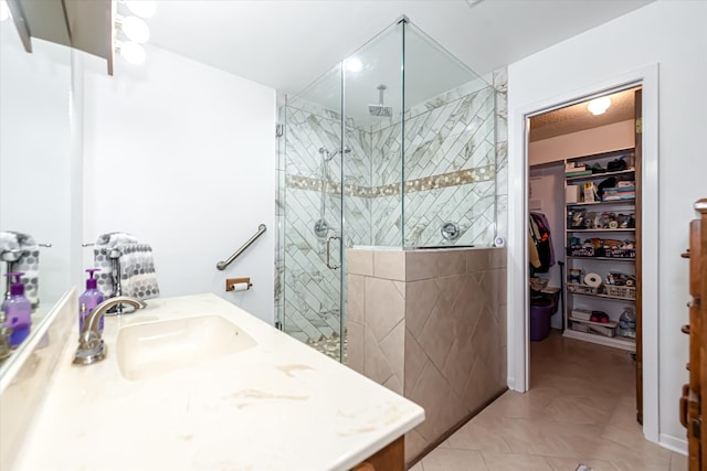 bathroom featuring a shower with door, tile flooring, and vanity