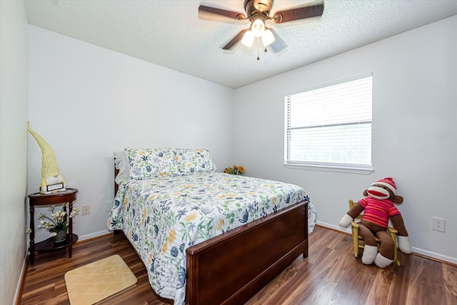 bedroom featuring ceiling fan, a textured ceiling, and dark wood-type flooring