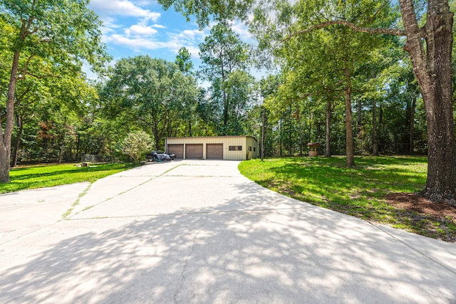 view of front of home with a garage, a front yard, and an outdoor structure