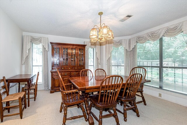 carpeted dining room featuring a textured ceiling and a chandelier