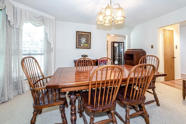 dining room featuring a notable chandelier and light carpet