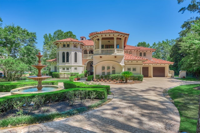 mediterranean / spanish-style house featuring a garage and a balcony