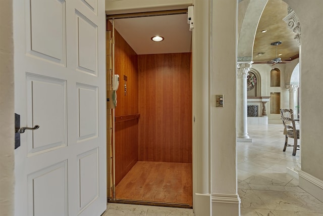 room details with tile floors, ceiling fan, elevator, and ornate columns