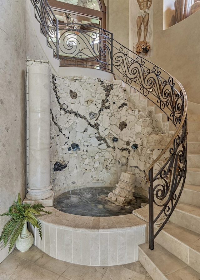 stairs with tile flooring and ornate columns