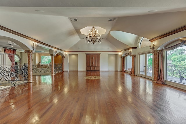 unfurnished living room featuring crown molding, a notable chandelier, vaulted ceiling, and hardwood / wood-style floors