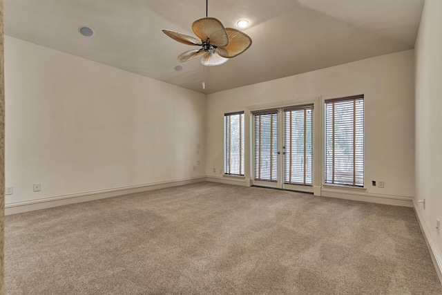 carpeted spare room featuring ceiling fan and vaulted ceiling