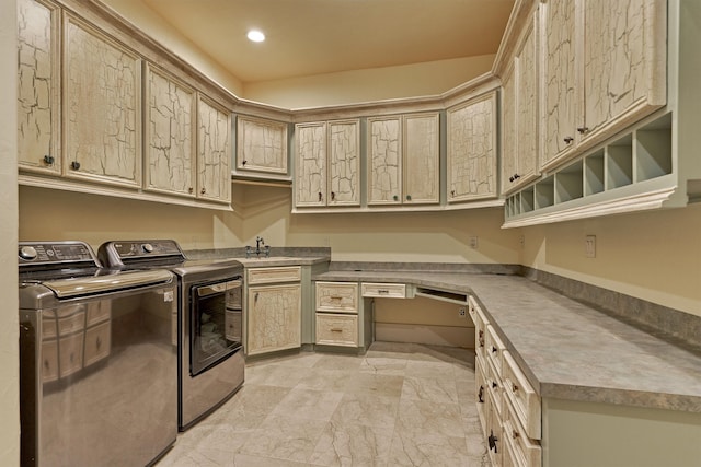 washroom featuring sink, washer and dryer, cabinets, and light tile floors