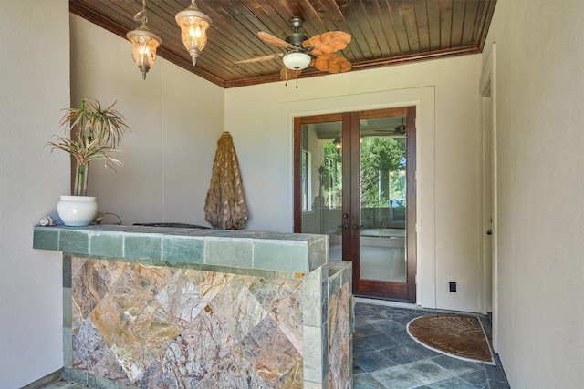 bar with ceiling fan, french doors, wood ceiling, ornamental molding, and dark tile floors