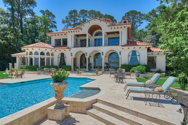 rear view of house featuring a patio area and a balcony